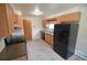 Kitchen featuring wood cabinets, black appliances, and ample counter space at 8450 Mason Cir, Westminster, CO 80031