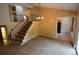 Carpeted living room featuring a staircase with an ornate railing and decorative wallpaper at 8450 Mason Cir, Westminster, CO 80031