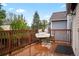 Back deck features a wood railing, egg chair with cushions, and views of the green landscaping at 3312 Meadow Ave, Broomfield, CO 80020