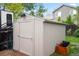 Tan backyard shed with access door, wood trim, and lawn and fence background at 3312 Meadow Ave, Broomfield, CO 80020