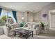 Bright living room with large sectional, window, gray walls, and plush carpet at 3312 Meadow Ave, Broomfield, CO 80020