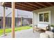Outdoor patio with wood beams, white furniture, and well-manicured lawn, perfect for relaxation at 3312 Meadow Ave, Broomfield, CO 80020