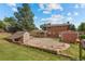 Expansive backyard featuring a brick house, sheds, and an empty in-ground pool area surrounded by stone edging at 1487 W Fair Ave, Littleton, CO 80120
