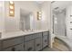 Bright bathroom with a gray vanity, decorative lighting, and a glass-enclosed shower at 1487 W Fair Ave, Littleton, CO 80120
