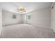 Spacious bedroom featuring neutral walls, gray carpeting, two windows and a ceiling fan at 1487 W Fair Ave, Littleton, CO 80120