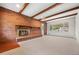 Cozy living room features a brick fireplace, wooden beams, and a large window at 1487 W Fair Ave, Littleton, CO 80120
