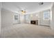 Spacious living room featuring a fireplace, neutral carpet, and large windows at 1487 W Fair Ave, Littleton, CO 80120
