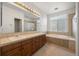 Bathroom with double sinks, tile countertops, a soaking tub, and a separate shower at 5322 Shetland Ct, Highlands Ranch, CO 80130