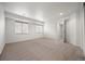 A neutral bedroom with two windows, beige carpet, and a walk-in closet at 5322 Shetland Ct, Highlands Ranch, CO 80130