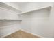 Walk-in closet with white shelves and neutral carpet at 5322 Shetland Ct, Highlands Ranch, CO 80130