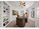 Office with built-in bookshelves, a large desk, and natural light from bay windows at 5322 Shetland Ct, Highlands Ranch, CO 80130