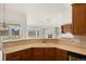 Open kitchen featuring wood cabinets, tile countertops, and a view into the living room with fireplace at 5322 Shetland Ct, Highlands Ranch, CO 80130