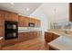 Well-lit kitchen with wood floors, cabinetry, and stainless steel appliances including a double oven at 5322 Shetland Ct, Highlands Ranch, CO 80130