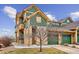 Tan and green two-story home with two-car garage and landscaping at 11932 W Long Cir # 201, Littleton, CO 80127