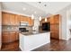 Modern kitchen with wood cabinets, granite countertops, and island at 11932 W Long Cir # 201, Littleton, CO 80127