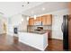 Bright kitchen features granite counters, wood cabinets, stainless appliances, and hardwood floors at 11932 W Long Cir # 201, Littleton, CO 80127