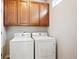 Bright laundry room, featuring upper cabinets and a washer and dryer at 11932 W Long Cir # 201, Littleton, CO 80127