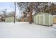 Snowy backyard with detached garage and storage shed at 1876 S Chester Cir, Denver, CO 80247