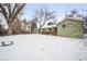 Snowy backyard with view of house and detached garage at 1876 S Chester Cir, Denver, CO 80247