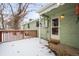 View of back door and snowy backyard with deck at 1876 S Chester Cir, Denver, CO 80247