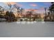 Attractive green Ranch home with snowy yard at sunset at 1876 S Chester Cir, Denver, CO 80247