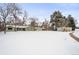 Green Ranch home with detached shed and snowy yard at 1876 S Chester Cir, Denver, CO 80247