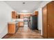 Kitchen with wood cabinets, stainless steel appliances, and laminate floor at 300 S Clinton St # 10C, Denver, CO 80247