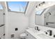 Modern bathroom with dual sink vanity, glass-enclosed shower, and a skylight at 2767 W 38Th Ave, Denver, CO 80211