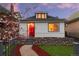 Charming home featuring a red front door, river rock landscaping, and blooming tree at 2767 W 38Th Ave, Denver, CO 80211