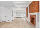 Spacious living room with brick fireplace open to dining room and kitchen with white cabinets at 2767 W 38Th Ave, Denver, CO 80211