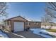 Front view of ranch home with attached garage and snow-covered landscaping at 5421 S Sherman St, Littleton, CO 80121