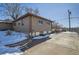 House exterior with snow, landscaping, and driveway at 5421 S Sherman St, Littleton, CO 80121