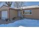 Tan colored ranch home with attached garage and snowy landscaping at 5421 S Sherman St, Littleton, CO 80121