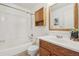 Bathroom featuring a vanity with a wood cabinet, shower-tub and a mirror at 19844 E Vassar Ave, Aurora, CO 80013