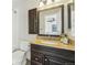 A cozy bathroom with dark wood vanity, mirror, granite countertop and shower/tub at 19844 E Vassar Ave, Aurora, CO 80013