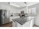 Bright, modern kitchen with white cabinets, stainless steel appliances, and gray counter tops at 19844 E Vassar Ave, Aurora, CO 80013