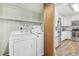 Laundry room including washer, dryer, shelving, and doorway to the bright updated kitchen at 19844 E Vassar Ave, Aurora, CO 80013