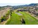 Aerial view features a lush green golf course with tranquil ponds and scenic surroundings at 7188 Raphael Ln, Littleton, CO 80125