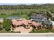 Breathtaking aerial view of a luxury home with a tile roof, lush landscaping, and golf course views at 7188 Raphael Ln, Littleton, CO 80125