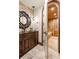 Elegant bathroom featuring a sauna, brick accents, decorative mirror, and dark wood cabinetry at 7188 Raphael Ln, Littleton, CO 80125