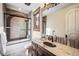 Bathroom featuring brick accents, a glass-enclosed shower and tub, and marble countertops at 7188 Raphael Ln, Littleton, CO 80125