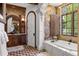 Lavish bathroom showcasing a soaking tub, stone accents, and elegant fixtures at 7188 Raphael Ln, Littleton, CO 80125