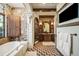 Beautiful bathroom boasts stone walls, brick archway, and a soaking tub at 7188 Raphael Ln, Littleton, CO 80125