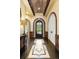 Grand foyer with arched doorways, decorative ceiling, and custom tile flooring at 7188 Raphael Ln, Littleton, CO 80125