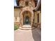 Elegant stone entryway with a decorative iron door and custom lighting at 7188 Raphael Ln, Littleton, CO 80125