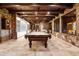 Recreational game room featuring a pool table, decorative ceiling, stone and brick walls, and tile flooring at 7188 Raphael Ln, Littleton, CO 80125