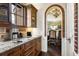 Charming kitchen with brick accents, granite countertops, and wooden cabinetry at 7188 Raphael Ln, Littleton, CO 80125