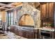 Kitchen with stone hood, stainless appliances, and custom cabinetry at 7188 Raphael Ln, Littleton, CO 80125