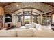 Bright and airy living room with a brick ceiling, fireplace, and large windows offering scenic views at 7188 Raphael Ln, Littleton, CO 80125