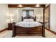 Comfortable main bedroom with a dark wood bed frame and patterned bedding at 7188 Raphael Ln, Littleton, CO 80125